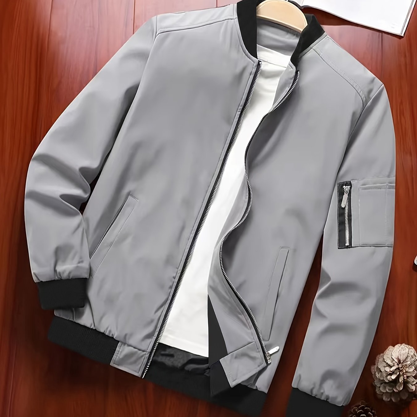 Տղամարդու նորաձև սև սպորտային առօրյա բաճկոն՝ թեթև բոմբեր՝ կայծակաճարմանդ գրպաններով, առջևի կայծակաճարմանդով և երիզավոր թևքերով։ Հիանալի է բացօթյա գործունեության, վազքի և առօրյա հագուստի համար։