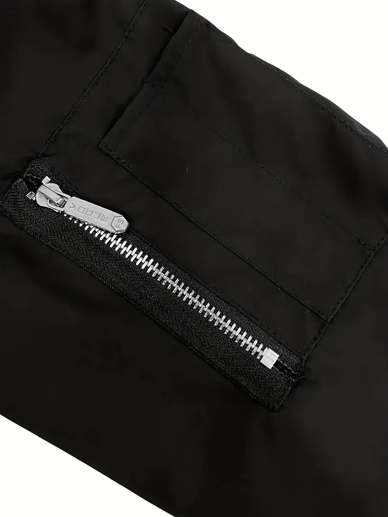 Տղամարդու նորաձև սև սպորտային առօրյա բաճկոն՝ թեթև բոմբեր՝ կայծակաճարմանդ գրպաններով, առջևի կայծակաճարմանդով և երիզավոր թևքերով։ Հիանալի է բացօթյա գործունեության, վազքի և առօրյա հագուստի համար։