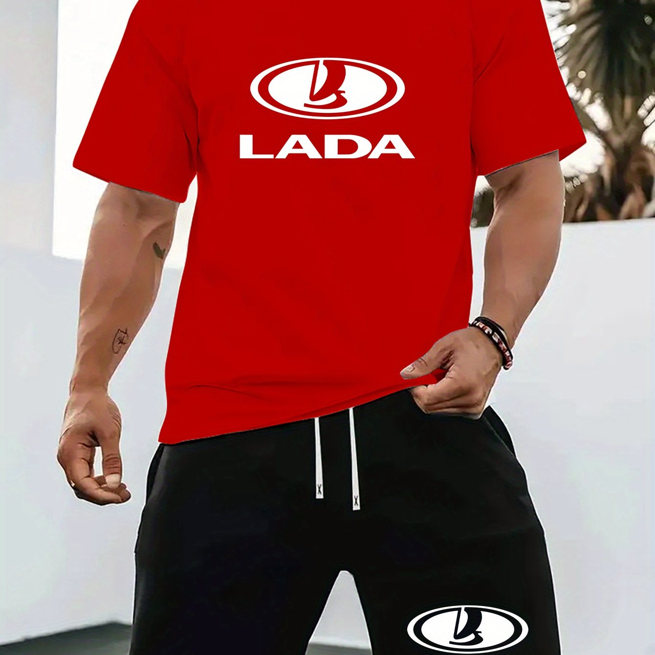 Տղամարդկանց ամառային առօրյա սպորտային երկու մասից բաղկացած հավաքածու՝ LADA տառերով նախշերով շապիկ և սև լարով շորտեր, առօրյա սպորտային հագուստ, սովորական չափս՝ իդեալական ամառային բացօթյա օգտագործման համար։