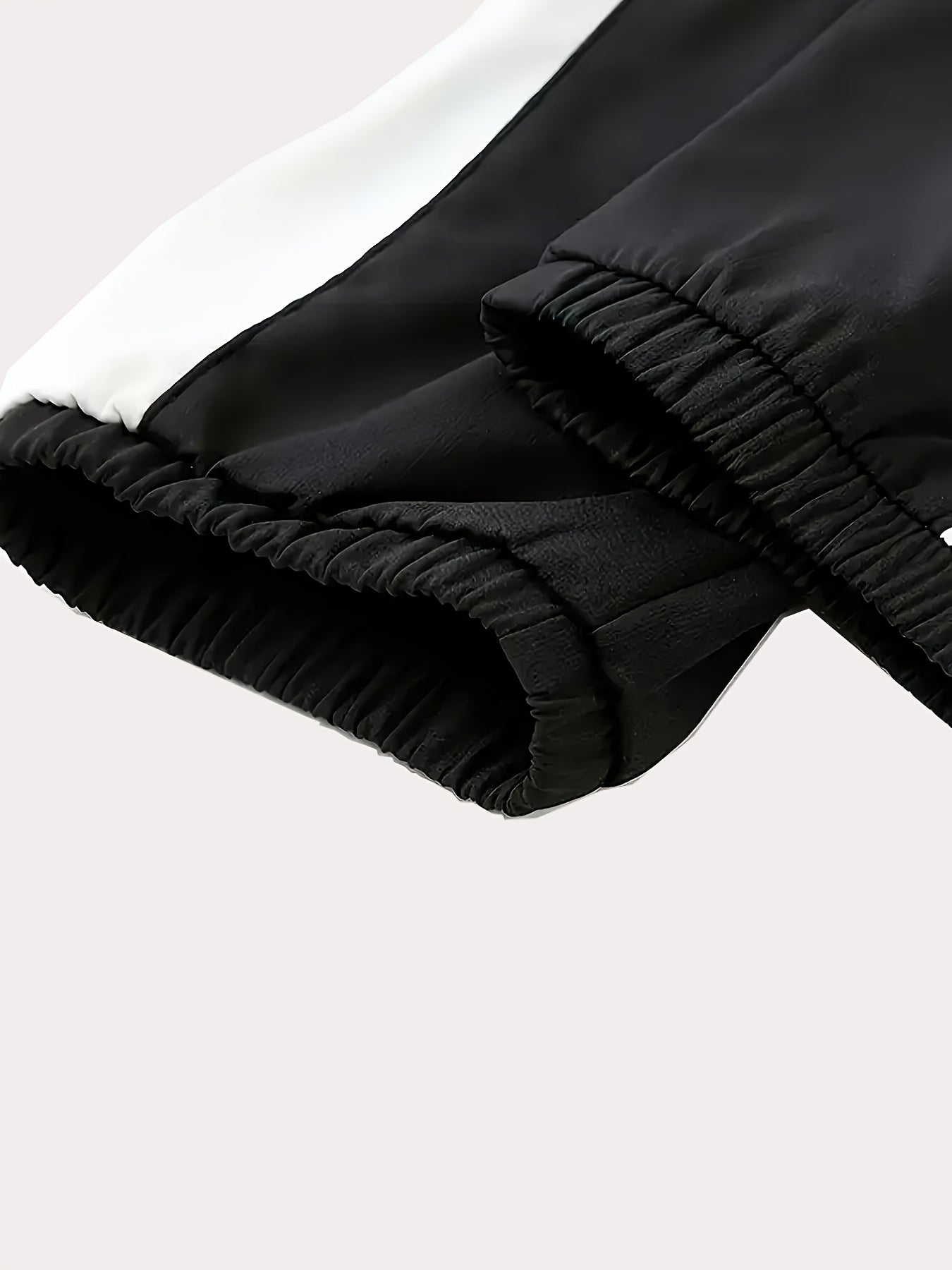 Գարնան և աշնան համար նախատեսված սպորտային հագուստի համալիր, որը ներառում է կանգնած օձիքով և սև ու սպիտակ գծավոր երկար տաբատով ճարմանդով բաճկոն, ոճային հանդերձանք, որը հիանալի նվեր է, քրտինքից պաշտպանված, միայն ձեռքով լվանալ, մարզումների համար աքսեսուար: