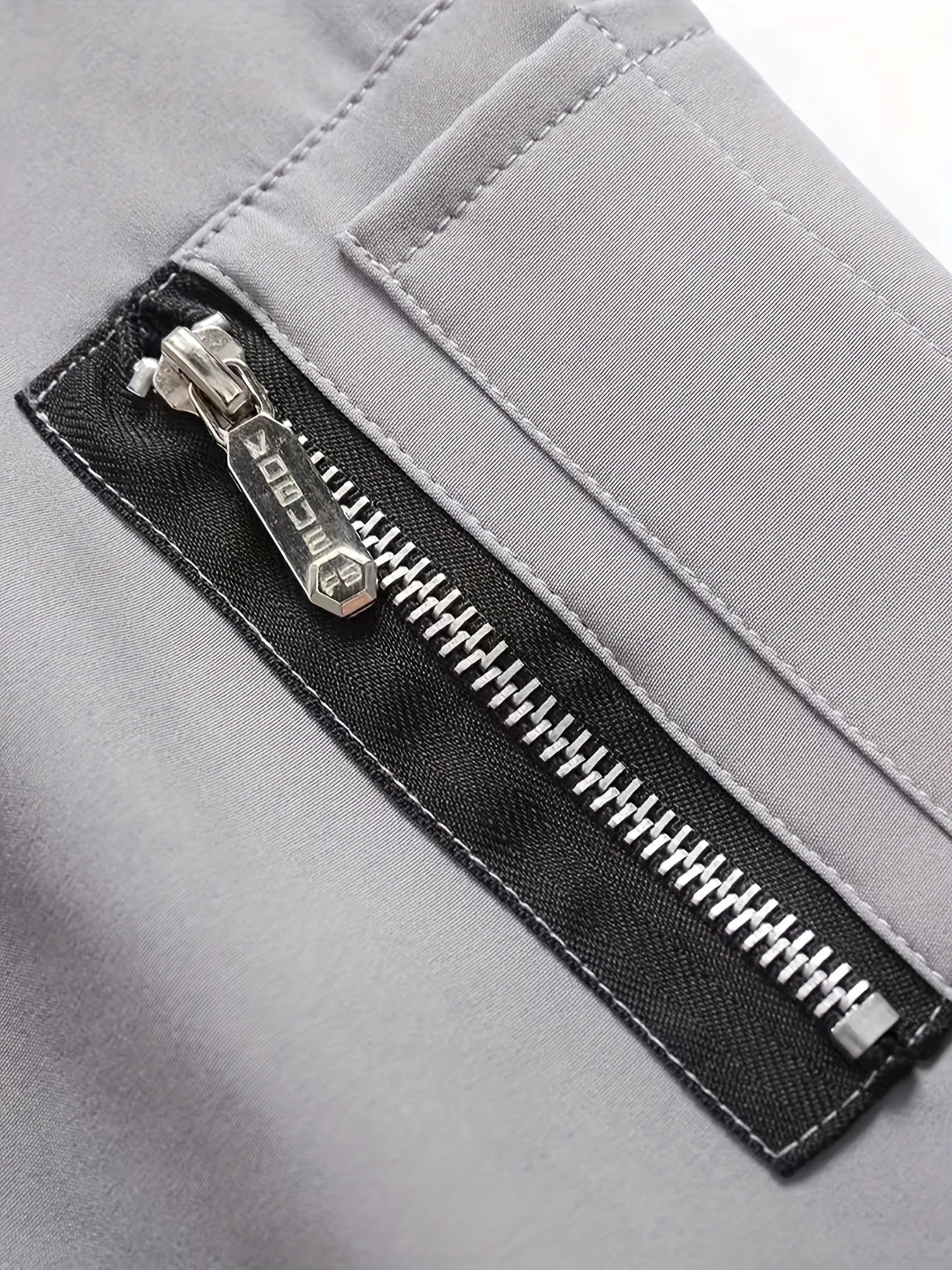 Տղամարդու նորաձև սև սպորտային առօրյա բաճկոն՝ թեթև բոմբեր՝ կայծակաճարմանդ գրպաններով, առջևի կայծակաճարմանդով և երիզավոր թևքերով։ Հիանալի է բացօթյա գործունեության, վազքի և առօրյա հագուստի համար։